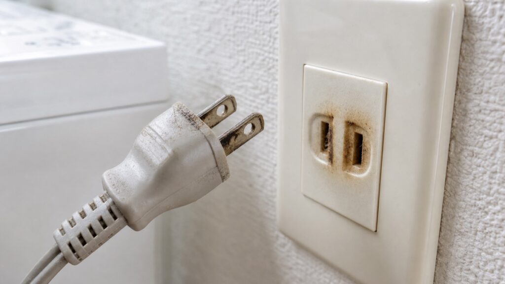 洗濯機の漏電や火災につながる焦げ跡が残るプラグとコンセント